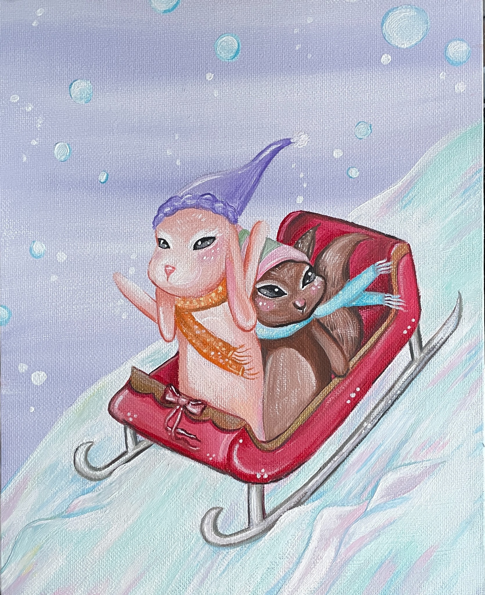 Two friends riding a bright red sled down a snowy hill